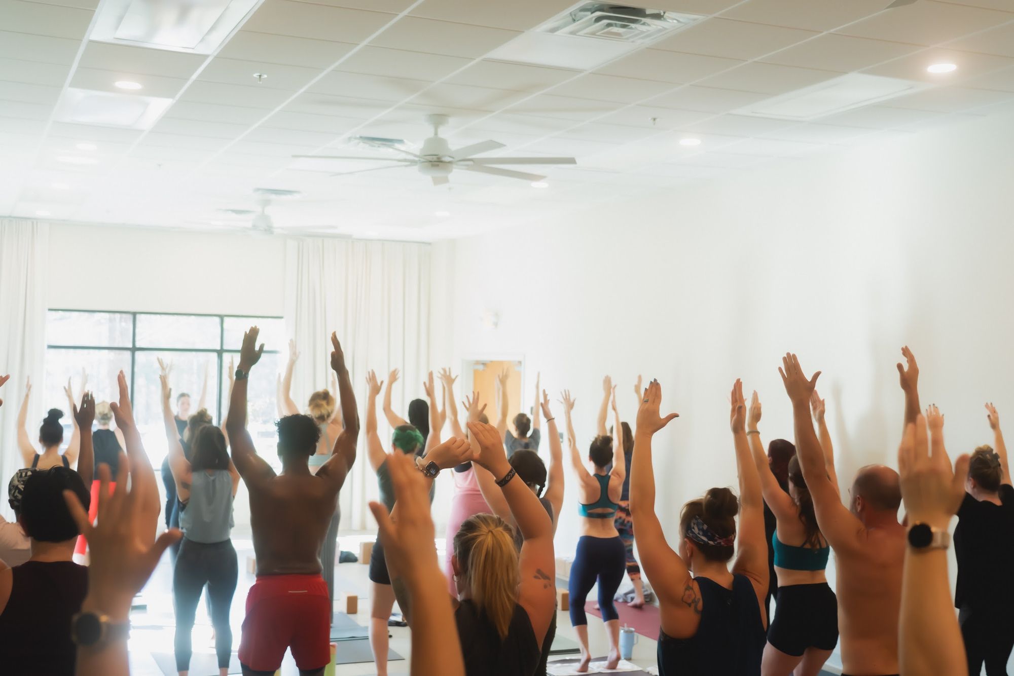 A full Mindful Owl class standing in prayer