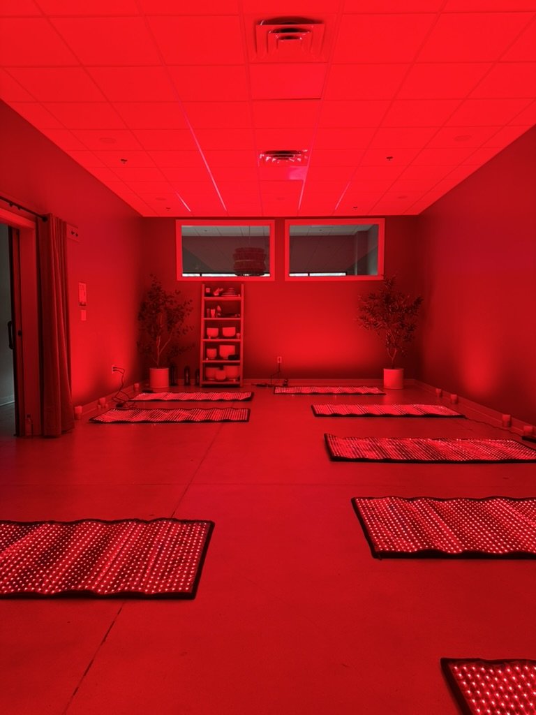 The studio set for Radiant Yin with ten red light mats glowing in a dim red room