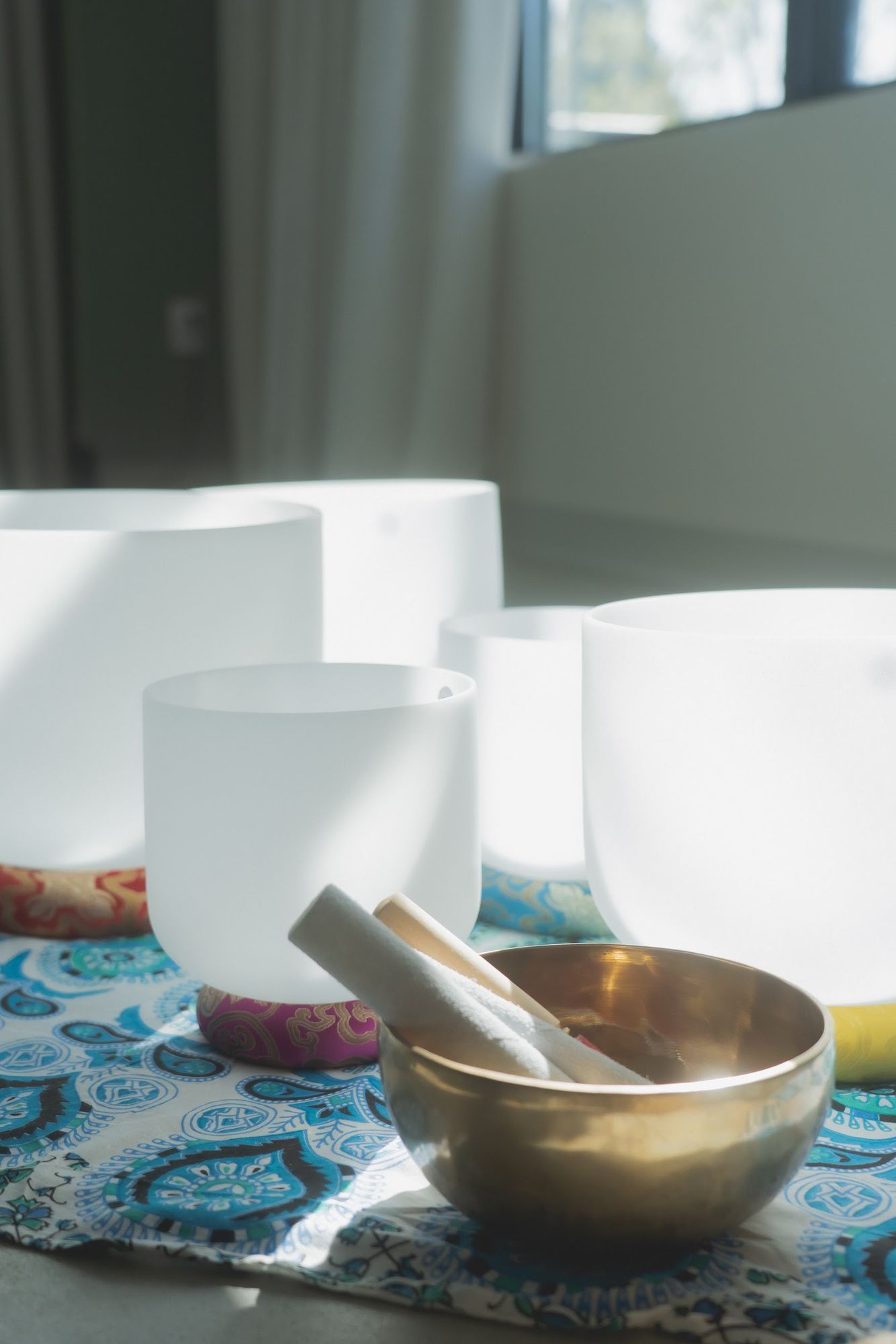 Close-up of crystal singing bowls and a brass bowl