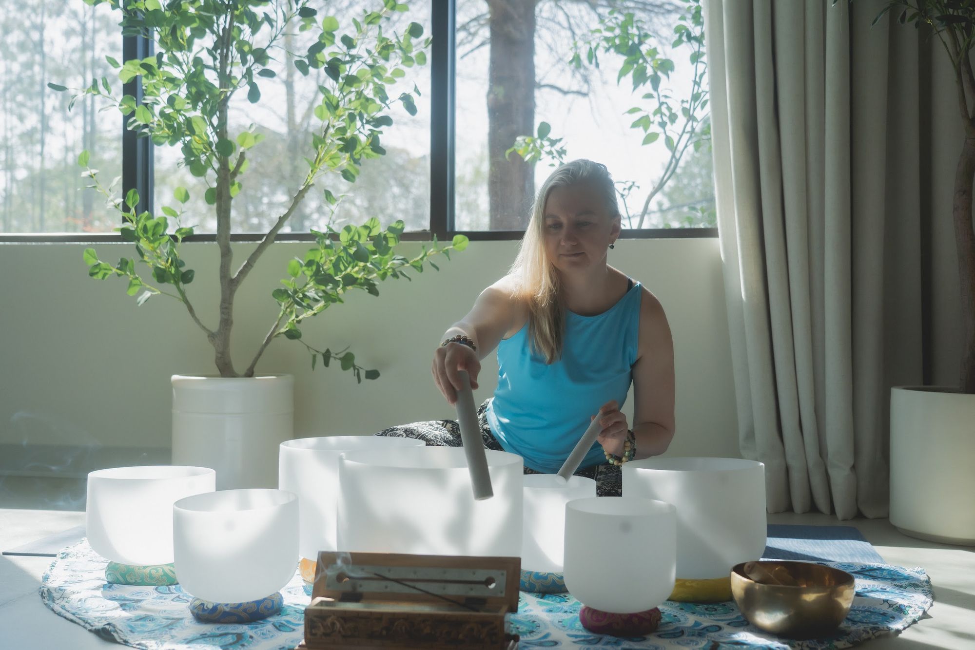 Crystal singing bowls being played in the sunlit studio